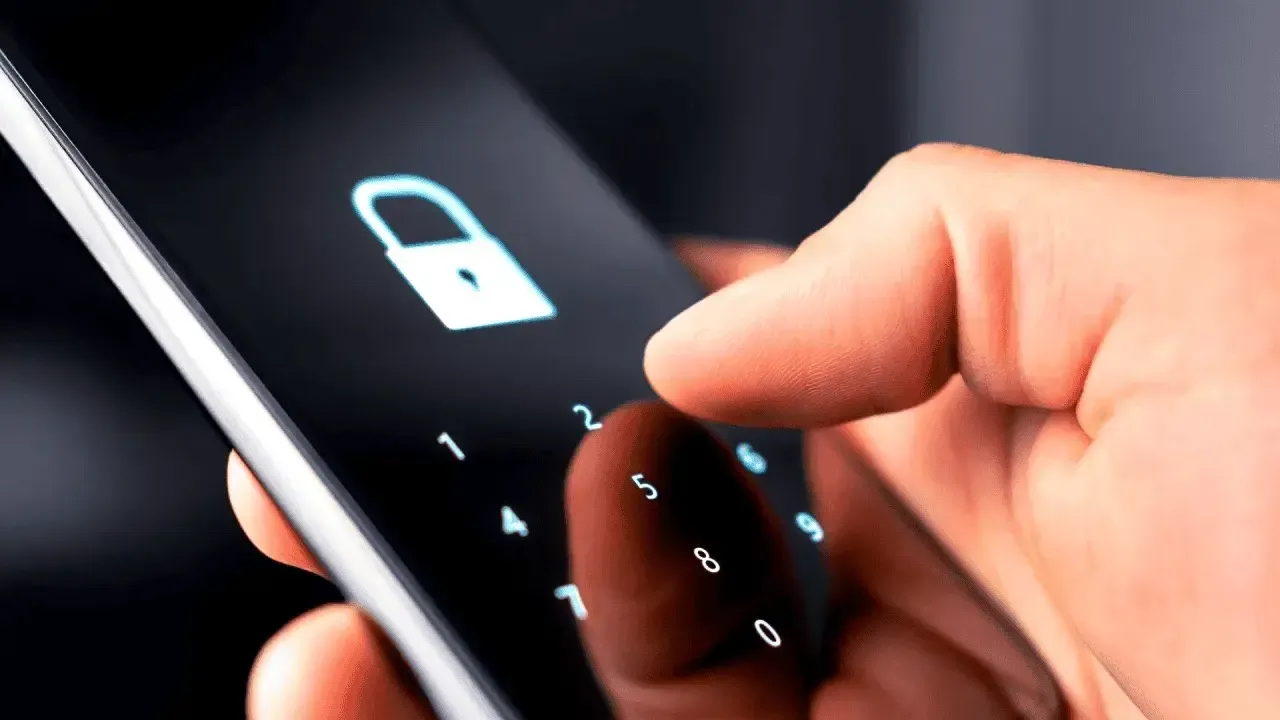Pessoa digitando código de segurança em smartphone com ícone de cadeado na tela.
